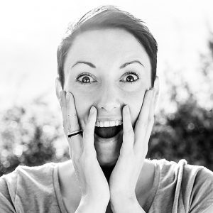 A woman smiling animatedly with crowned teeth.