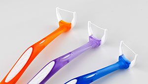 Plastic flossers lined up next to each other, a good tool for preventing gum disease.