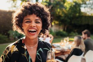 A young woman smiling happily with her recently whitened teeth.